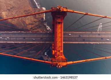 Luchtfoto van Golden Gate Bridge in mistig zicht tijdens de avond tijd, grootstedelijke transportinfrastructuur, vogelperspectief van autovoertuigen op de weg van de ophangingsconstructie 