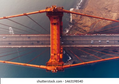 Aerial View Of Golden Gate Bridge In Foggy Visibility During Evening Time, Metropolitan Transportation  Infrastructure, Birds Eye View Of Automotive Car Vehicles On Road Of Suspension Construction 