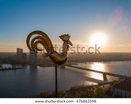 Aerial view of the golden rooster over the Riga city. Beautiful sunset view. 