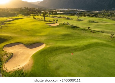 Aerial view of a golf club field at sunset on Tenerife Island, Canary Islands, Spain. Golf course on the rocky coast of Tenerife island, picturesque scene with sunset light. Luxury destination scene - Powered by Shutterstock