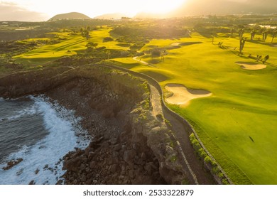 Aerial view of a golf club field at sunset on Tenerife Island, Canary Islands, Spain. Golf course on the rocky coast of Tenerife island, picturesque scene with sunset light. Luxury destination scene - Powered by Shutterstock