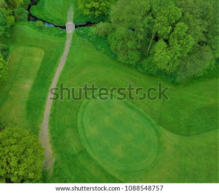 Similar – A tranquil aerial view of a lush golf course fairway, bathed in the warm glow of sunset. Ideal for themes of relaxation, nature, and sports, this image captures the peaceful beauty of the golfing experience.