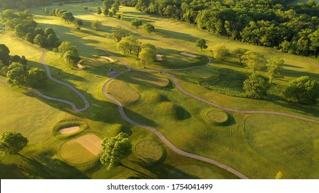 Aerial View Of Golf Course. Establishing Shot, Drone Flying Over Golf Club. Early Morning, Summertime, Sunlight