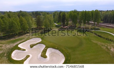 Aerial view of golfers playing on putting green. Professional players on a green golf course.