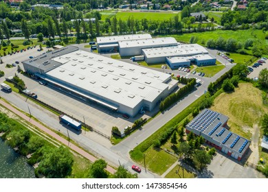 Aerial view of goods warehouse. Logistics center in industrial city zone from above. Aerial view of trucks loading at logistic center. View from drone. 