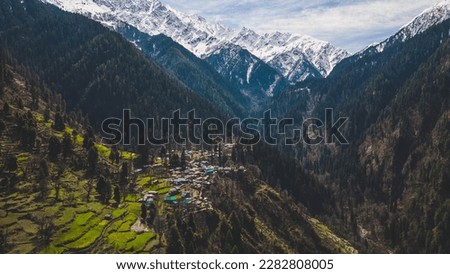aerial view of Grahan Village - India's Most Beautiful and Hidden village at Himalayas mountains surrounded by snow mountain - Kasol, India