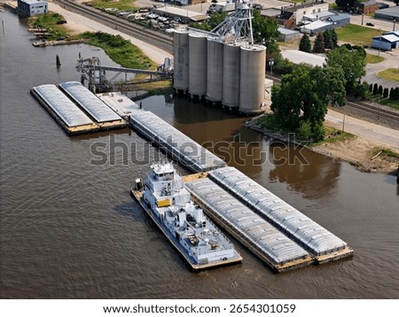 Aerial view of grain elevators with a tug boat getting ready to transport loaded grain barges
