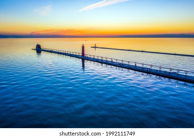 Aerial view of the Grand Haven Pier Lights as the sun sets over Lake Michigan, located where the Grand River meets Lake Michigan at Park