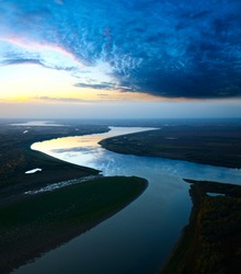 It Is Aerial View The Great River During Twilight. On The River Is Calm Now. Beautiful Clouds Are Reflected In Quiet Water.