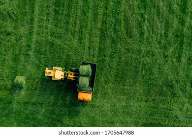 Aerial View Of Green Grass Harvest Field With Tractor Moving Hay Bale In Finalnd