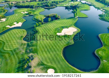Aerial view of green grass and trees on a golf field.