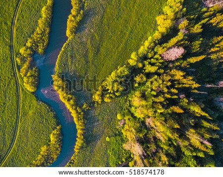 Aerial view of green meadow and small river