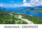 Aerial view of green meadows, hills and the road. Top view from drone of rural road mountains. Beautiful landscape with roadway, green grass, sky with clouds in Golo Mori, Labuan Bajo Flores Indonesia