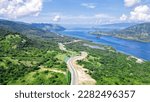 Aerial view of green meadows, hills and the road. Top view from drone of rural road mountains. Beautiful landscape with roadway, green grass, sky with clouds in Golo Mori, Labuan Bajo Flores Indonesia