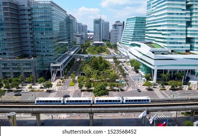 Aerial View Of A Green Open Space Surrounded By Modern Office Buildings And A Metro Train Traveling On The Elevated Rails Of Wenhu MRT Line On A Sunny Day, In Nankang Software Park, Taipei, Taiwan