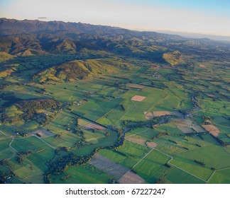 Aerial view of green paddocks, hills and mountains in the Wairarapa District, New Zealand