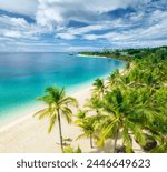 Aerial view of green palm trees, on the empty sandy beach of Indian Ocean at sunset. Summer in Kendwa, Zanzibar island. Tropical landscape with palms, white sand, blue sea, sky with clouds. Top view