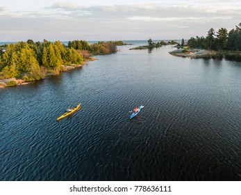 An aerial view group of seniors in sea kayaks camping and paddling on the Great Lakes in northern Canada. - Shutterstock ID 778636111
