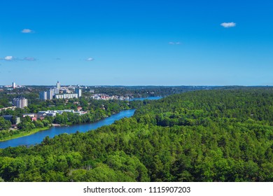 Aerial View From Hammarby Hill Over River, Green Forest Of Nacka Nature Reserve On One Side, White Buildings On Another Side. Neighborhood Of City And Nature In Stockholm, Sweden. Ecological Concept.