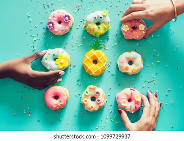 Aerial view of hands picking donuts - Powered by Shutterstock