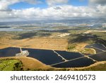 Aerial view of Hawaiian island of Oahu  with solar engery fields and the towns of Waipahu and Pearl City in the background against blue sky with clouds