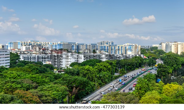 Aerial view HDB housing complex near highway\
with lot of green trees and vehicles in traffic, cloud blue sky.\
Singapore is an excellent green, clean city. Asia transportation,\
infrastructure concept.