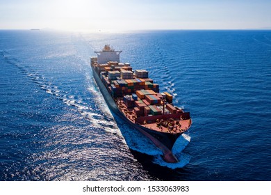 Aerial View Of A Heavy Loaded Container Cargo Vessel Traveling In Full Speed Over Blue Ocean