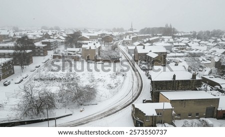 Aerial view of heavy snowfall in Morley, Leeds, January 5th 2025 with snow covered roads and houses. A grey and white wintry scene
