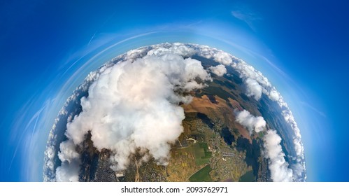 Aerial view from high altitude of little planet earth covered with white puffy cumulus clouds on sunny day