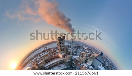 Aerial view from high altitude of little planet earth with cement factory high concrete structure and tower crane at industrial production area in evening. Manufacture and global industry concept
