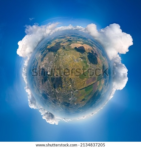 Aerial view from high altitude of little planet earth covered with white puffy cumulus clouds on sunny day