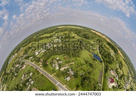 Aerial view from high altitude tiny planet in sky with clouds overlooking old town, urban development, buildings and crossroads. Transformation of spherical 360 panorama in abstract aerial view.