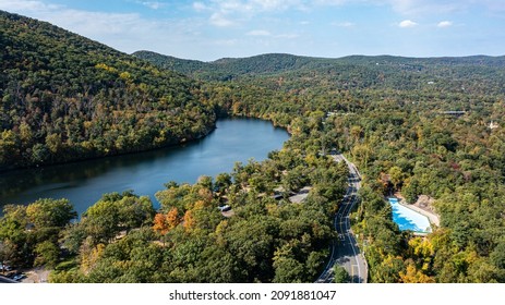 Aerial view, high up over a calm Hudson River on a sunny day with blue skies, it is a high angle shot, taken with a drone camera by the Bear Mountain Bridge.