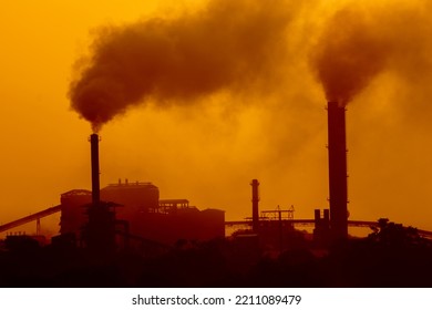 Aerial View Of High Smoke Stack With Smoke Emission. Plant Pipes Pollute Atmosphere. Silhouette Background.