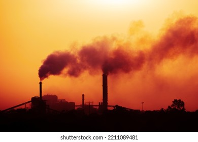 Aerial View Of High Smoke Stack With Smoke Emission. Plant Pipes Pollute Atmosphere. Silhouette Background.