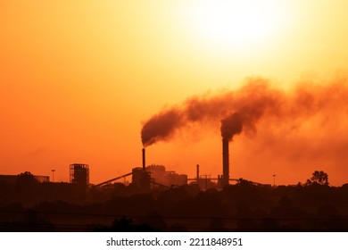 Aerial View Of High Smoke Stack With Smoke Emission. Plant Pipes Pollute Atmosphere. Silhouette Background.