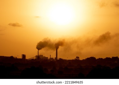 Aerial View Of High Smoke Stack With Smoke Emission. Plant Pipes Pollute Atmosphere. Silhouette Background.