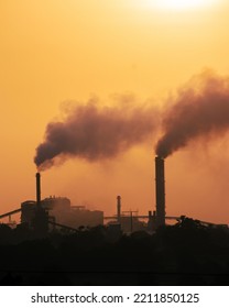 Aerial View Of High Smoke Stack With Smoke Emission. Plant Pipes Pollute Atmosphere. Silhouette Background.