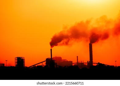 Aerial View Of High Smoke Stack With Smoke Emission. Plant Pipes Pollute Atmosphere. Silhouette Background.