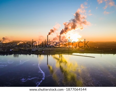 Aerial view of high smoke stack with smoke emission. Plant pipes pollute atmosphere. Industrial factory pollution, smokestack exhaust gases. Industry zone, thick smoke plumes. Climate change, ecology