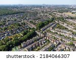 Aerial view Highams Park, a residential neighbourhood surrounded by forest and green parks on the outskirts of London. upmarket residential houses, and semi detached homes in the morning summer sun