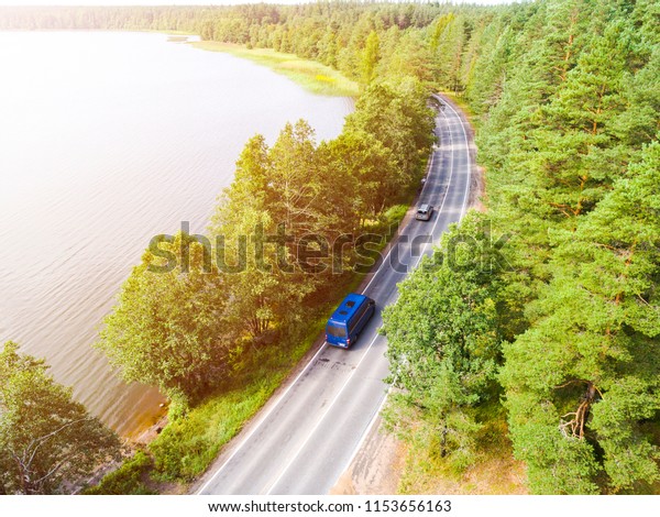 Aerial view of highway\
with car. Aerial view of a country road with moving car. Car\
passing by. Aerial road. Aerial view flying. Captured from above\
with a drone. Soft\
lighting
