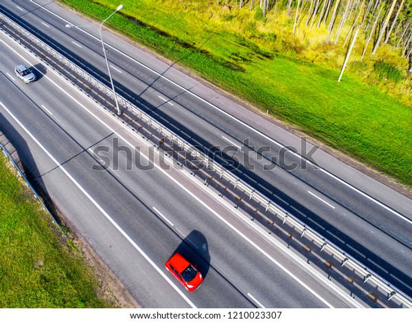 Aerial view of highway. Car crossing interchange\
overpass. Highway interchange with traffic. Aerial bird\'s eye photo\
of highway. Expressway. Road junctions. Car passing. View from\
above. Car in motion