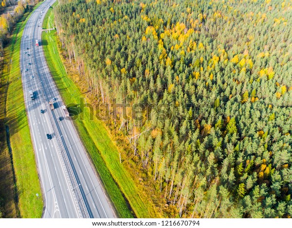 Aerial view of highway. Cars crossing interchange\
overpass. Highway interchange with traffic. Aerial bird\'s eye \
highway. Expressway. Road junctions. Car passing. Top view from\
above. Cars in motion