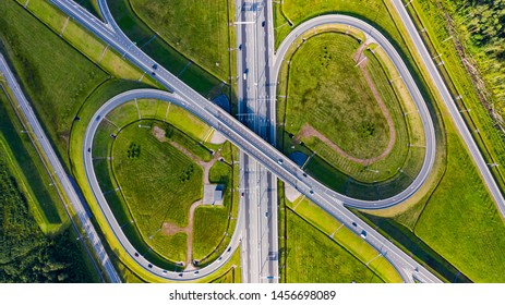 Aerial View Of Highway In City. Cars Crossing Interchange Overpass. Highway Interchange With Traffic. Aerial Bird's Eye Photo Of Highway. Expressway. Road Junctions. Car Passing. Top View From Above.