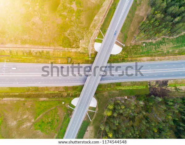Aerial view of highway in city. Cars crossing
interchange overpass. Highway interchange with traffic. Aerial
bird's eye photo of highway. Expressway. Road junctions. Car
passing. Top view from above.
