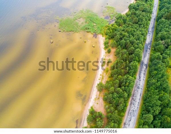 Aerial view of highway.\
Aerial view of a country road near the lake. Car passing by. Aerial\
road. Aerial view flying. Captured from above with a drone. Soft\
lighting