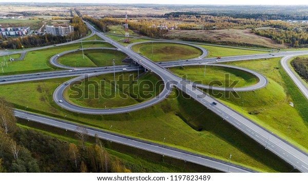 Aerial view of highway\
interchange  Road junction Aerial photo of a highway going through\
the forest