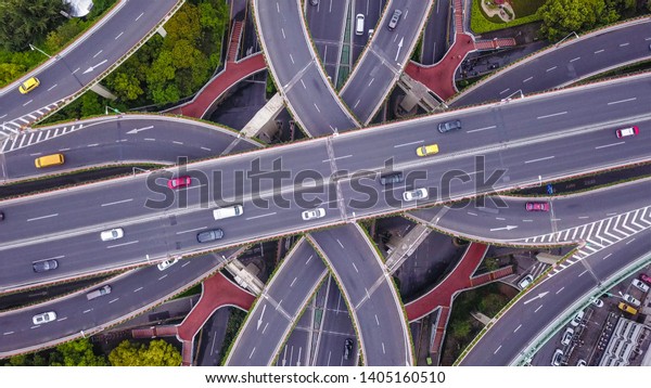 Aerial view of highway junctions shape letter x\
cross. Bridges, roads, or streets with trees in transportation\
concept. Structure shapes of architecture in urban city, Shanghai\
Downtown, China.