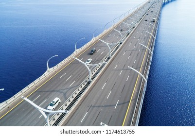 Aerial View Of Highway In The Ocean. Cars Crossing Bridge Interchange Overpass. Highway Interchange With Traffic. Aerial Bird's Eye Highway. Expressway. Road Junction. Car Passing. Bridge With Traffic